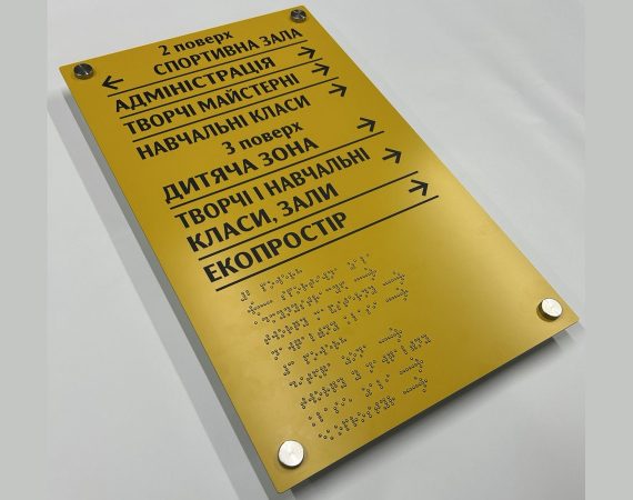 Жовта навігаційна табличка другого і третього поверхів зі стрілками та підписами шрифтом Брайля