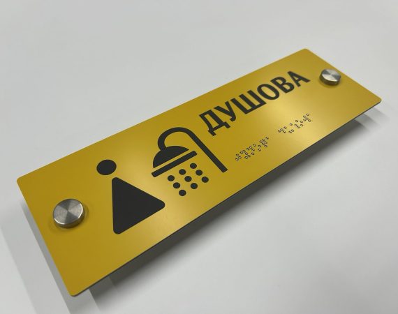 Жовта табличка «Душова» з піктограмою душу та написом шрифтом Брайля