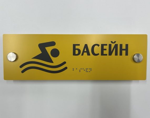 Жовта табличка «Басейн» з піктограмою плавця та написом шрифтом Брайля