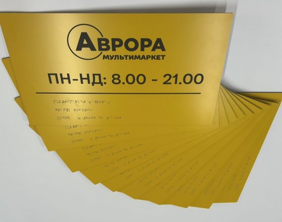 Жовті таблички «Аврора» з графіком роботи і шрифтом Брайля, розкладені віялом