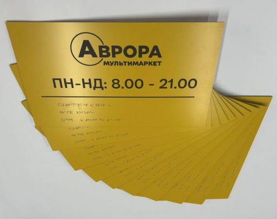 Жовті таблички «Аврора» з графіком роботи і шрифтом Брайля, розкладені віялом