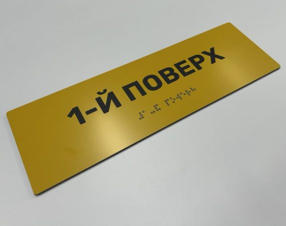 Жовта табличка «1-й поверх» із рельєфним написом шрифтом Брайля